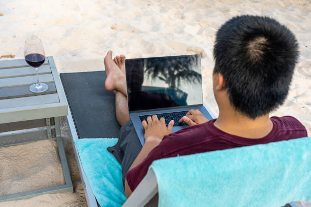 istock High angle view of freelancer typing laptop keyboard on beach 1154257990