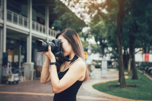 istock Asian female photographer with professional camera. 1154266517