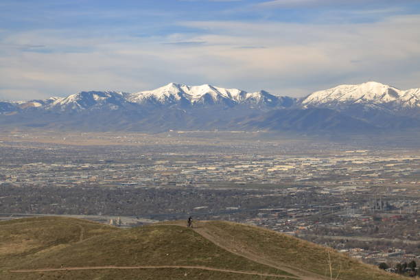 Salt Lake City aerial skyline view with a park in the foreground, downtown to the right, and the Wasatch Range mountain range far in the distance.