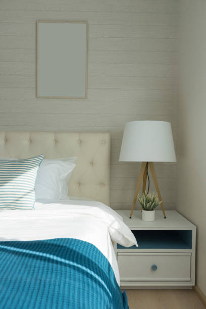 istock White lamp next to bed with navy blue bedding. 1154281309