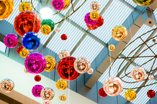 Colorful christmas baubles hanging on shopping mall.