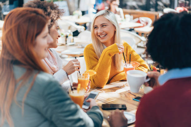 istock Happy friends talking and laughing at cafe 1154282512