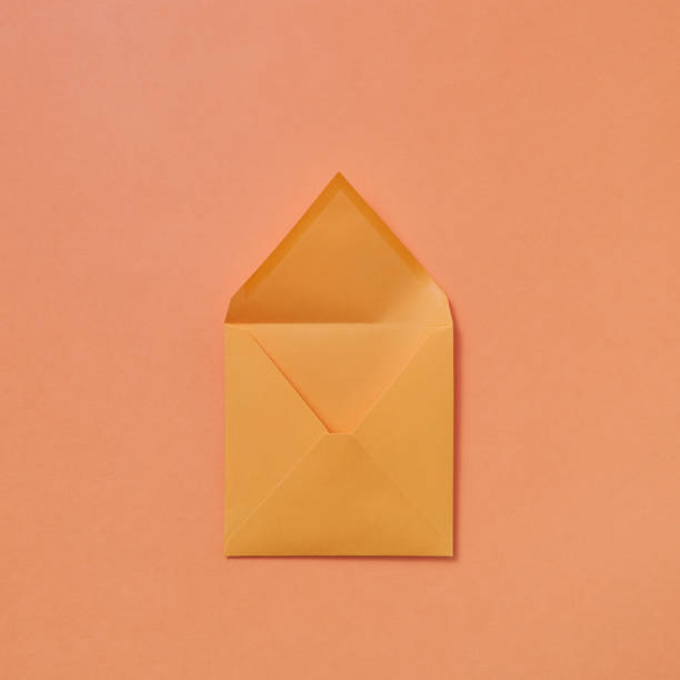 istock Handmade blank mock-up envelope on a peach color background. 1154301764