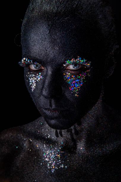 istock Girl in black makeup with sparkles 1154306283