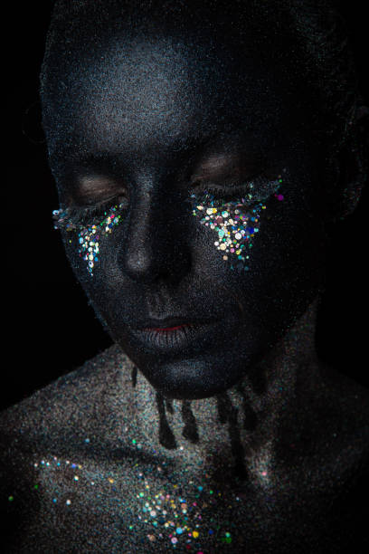 istock Girl in black makeup with sparkles 1154306302