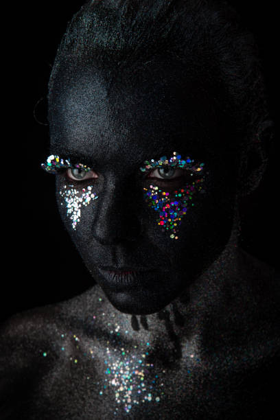 istock Girl in black makeup with sparkles 1154306335