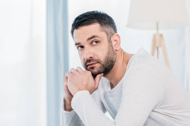 istock handsome bearded man propping chin with hands at home 1154319661