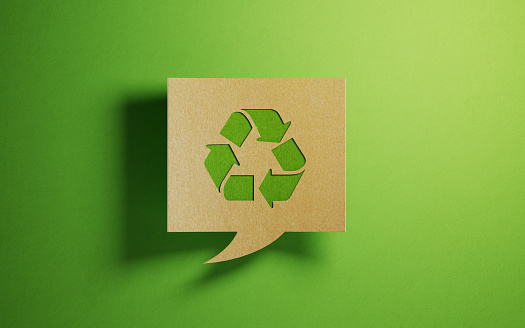 Burbuja de chat hecha de papel reciclado sobre fondo verde photo