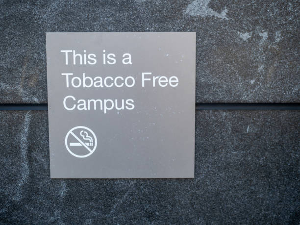 questo è un cartello del campus senza tabacco e un logo pubblicato fuori dall'edificio - dipping tobacco foto e immagini stock