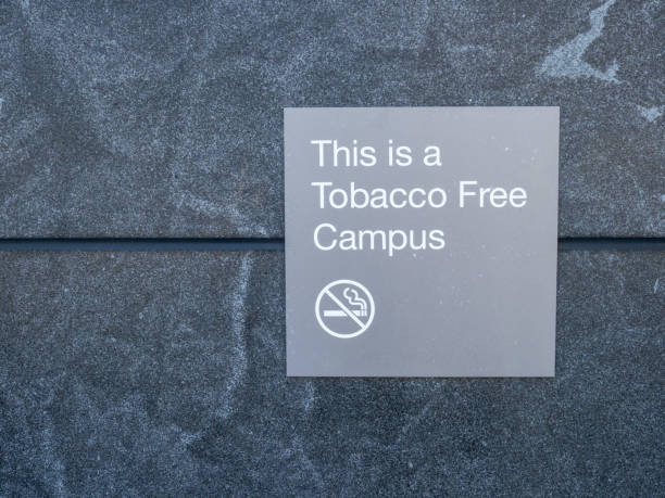 questo è un cartello grigio campus senza tabacco e logo pubblicato al di fuori dell'edificio - dipping tobacco foto e immagini stock