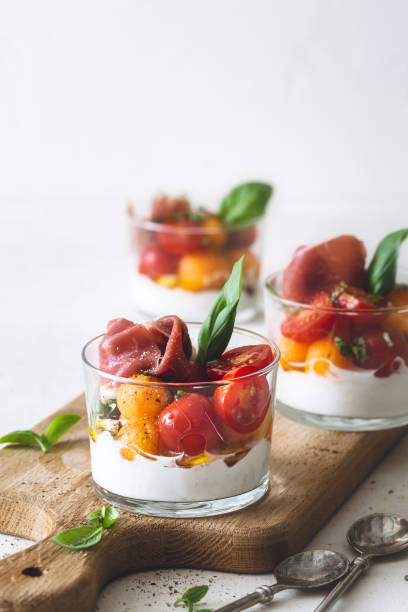 verrine melon cantaloupe, tomatoes, ricotta cheese, parma ham and basil - appetizer bruschetta meal lunch imagens e fotografias de stock