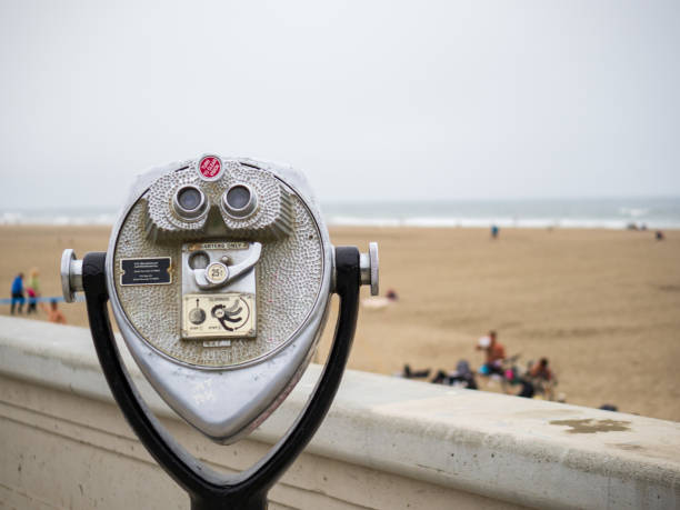 istock Tower viewer telescope and binoculars looking off to ocean and beach on overcast day with storm coming 1154324280