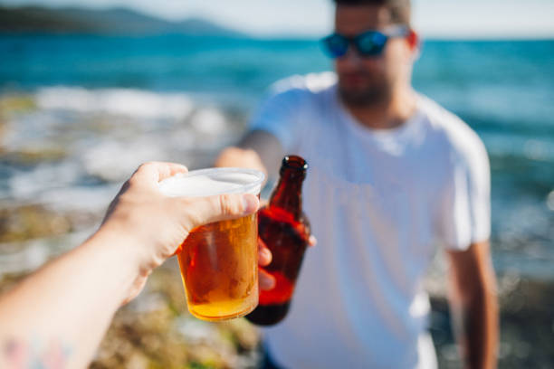 istock Friends toasting beer at beach 1154326168