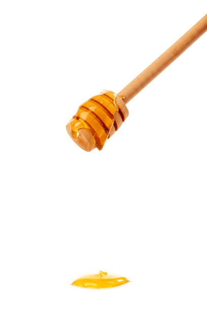 istock honey with wooden drizzler isolated on white background 1154330409