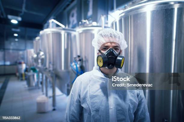Industriële Plant Werknemer Draagt Masker En Gevaar Pak Voor Bescherming Stockfoto en meer beelden van Chemische fabriek