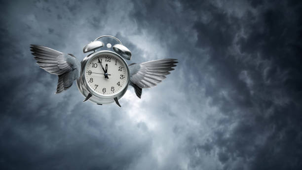 времена летит концепция с крыльями на будильник в небе - время летит стоковые фото и изображения