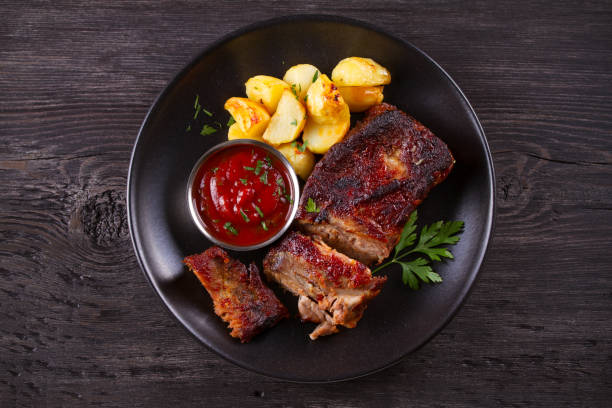 istock Roasted pork spare ribs with potatoes. Grilled meat 1154335455