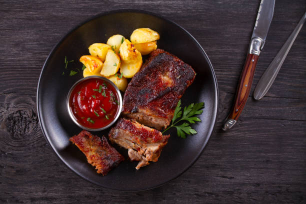 istock Roasted pork spare ribs with potatoes. Grilled meat 1154335492
