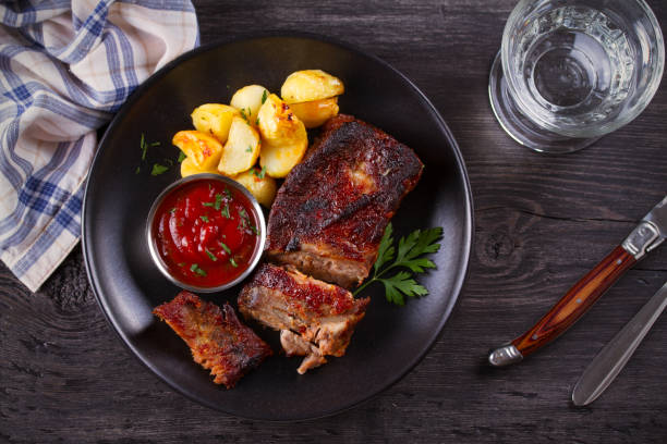 istock Roasted pork spare ribs with potatoes. Grilled meat 1154336340
