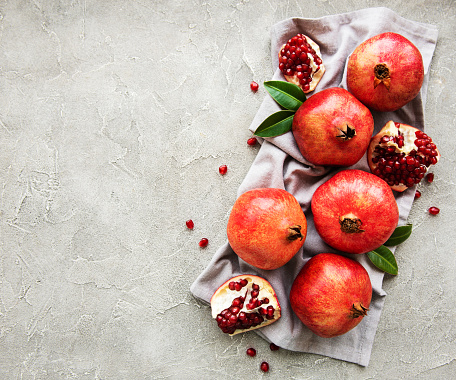 Juicy and ripe pomegranates  on a grey concrete  background