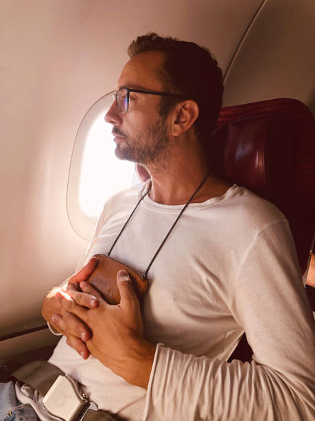 istock Airplane passenger with a neck bag for safe carrying money and documents. 1154337437