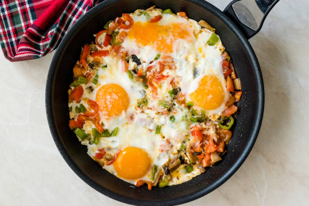 istock Fried Eggs with Vegetables in Pan Cooking 1154338479