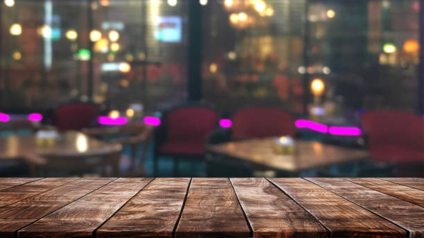 istock Empty wood table top on abstract blurred restaurant and nightclub lights background - can be used for display or montage your products 1154338700