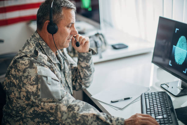 istock Army soldier wearing headphones and using computer 1154340689