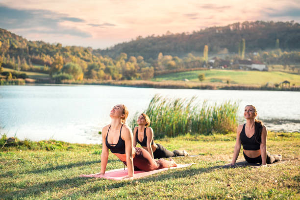istock Women doing yoga on the lake 1154342903
