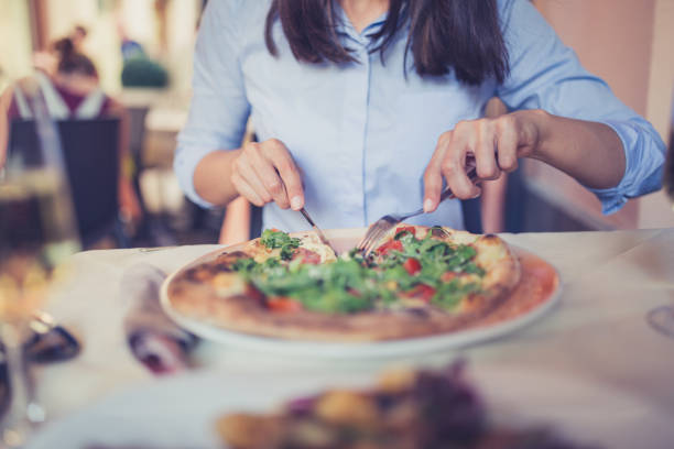 istock Young Italian women enjoying after work in restaurant, eating pizza 1154343295