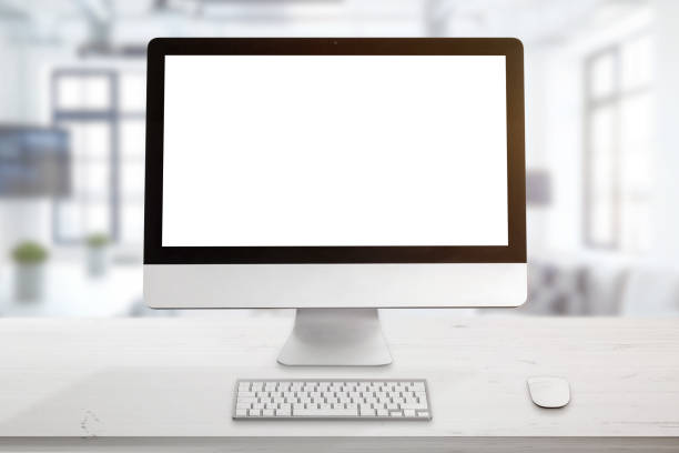 istock Clean office desk with computer display, keyboard and mouse. Isolated screen for mockup. Office in background. 1154348322