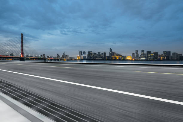 istock Empty asphalt road through modern city at dusk, China 1154348404