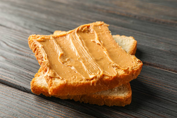 istock Peanut butter sandwich on wooden background, space for text and closeup 1154354734