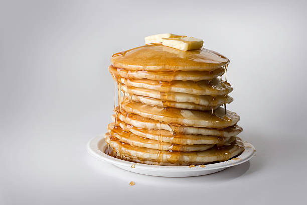 Precarious stack of pancakes with syrup and butter Mmmmmm. A delicious stack of pancakes.  butter photos stock pictures, royalty-free photos & images