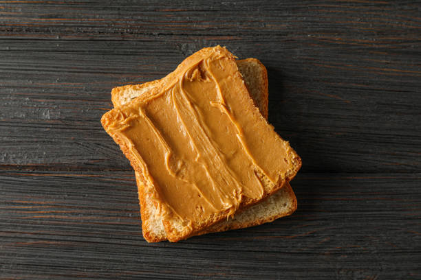 istock Peanut butter sandwich on wooden background, space for text and top view 1154354898