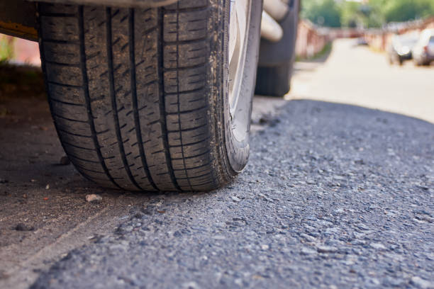 istock Black car tire on the road 1154358265