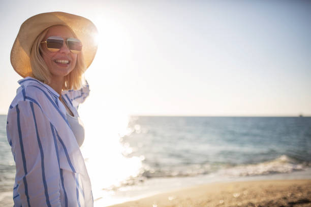 istock Woman watching sunset by the sea 1154358535
