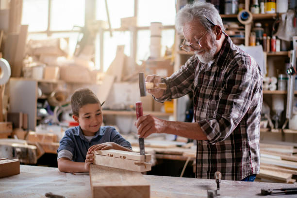 istock Senior carpenter and his grandson having fun in the workshop 1154360224