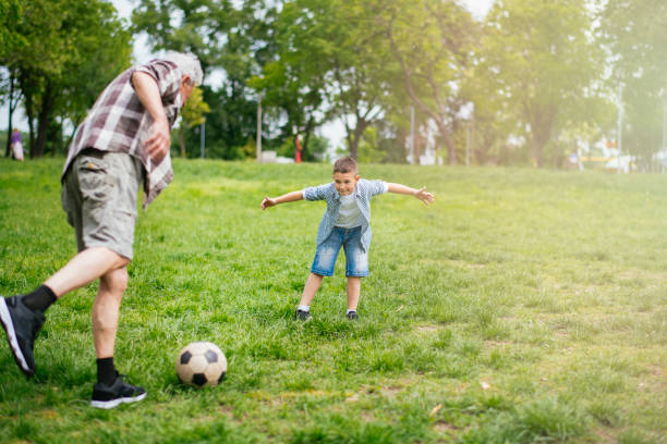 おじいちゃんと孫は楽しんで、サッカー - helmet child padding football helmet ストックフォトと画像
