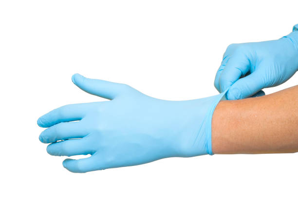 istock Doctor putting on protective blue gloves isolated on white background 1154361634
