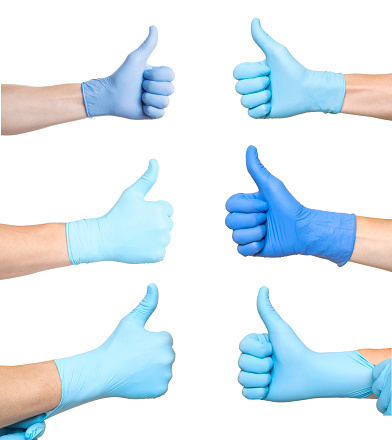 Doctor con guantes de látex azul dando signo de pulgar arriba. Como. Fondo blanco photo