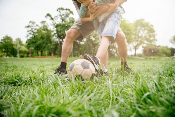 abuelo y nieto divirtiéndose, fútbol - helmet child padding football helmet fotografías e imágenes de stock