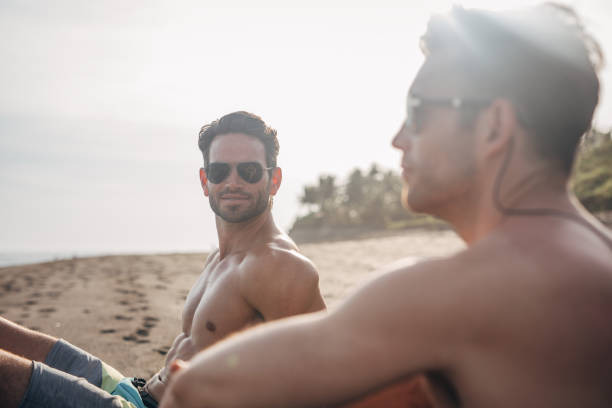istock Friends with surfboards at beach 1154362947