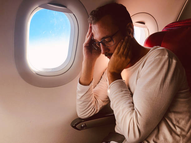 istock Tired / sick passenger in a modern airplane seat next to the window. 1154363035