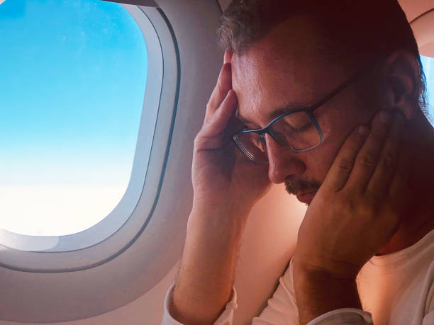 istock Tired / sick passenger in a modern airplane seat next to the window. 1154363063