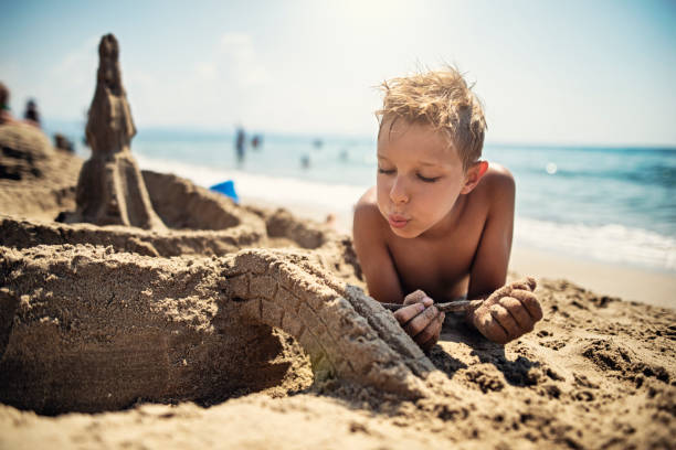 istock Little boy building sandcastle on beach 1154365062