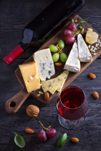 istock Red wine with cheese on chopping board. Wine and food concept 1154365162