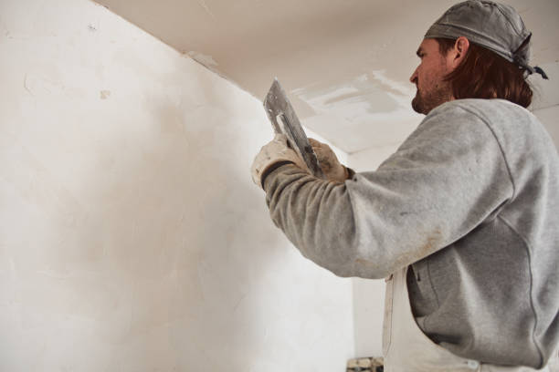 istock Workman plastering gypsum walls inside the house. 1154365264