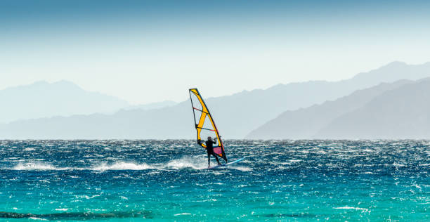 windsurfer rides on a background of high mountains in Egypt Dahab South Sinai windsurfer rides on a background of high mountains in Egypt Dahab dahab photos stock pictures, royalty-free photos & images