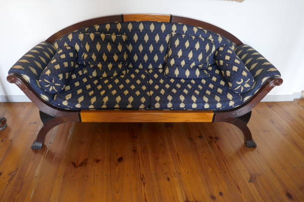 istock Antique blue patterned sofa on wooden floor in front of a white wall 1154372455